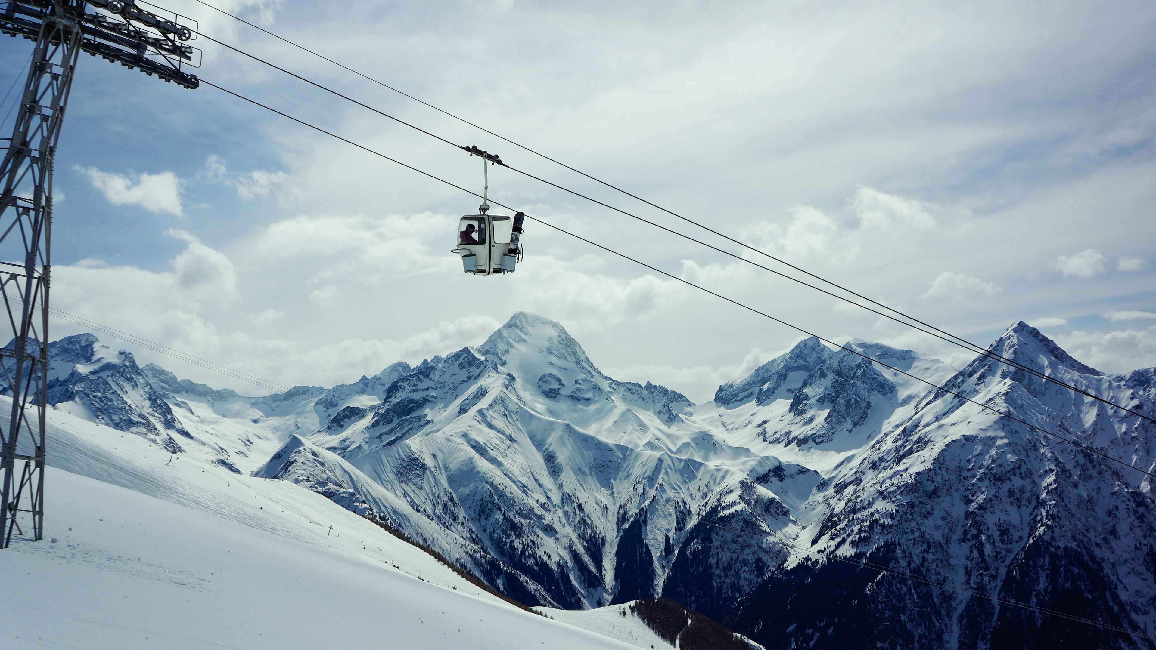 A cablecar going up a snowy mountain